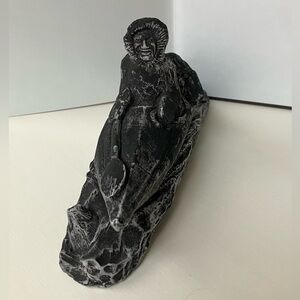 Inuit-style sculpture, depicting a person in a kayak or canoe with a seal